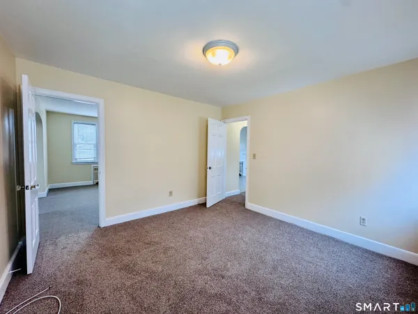 an empty room with closet and mirror
