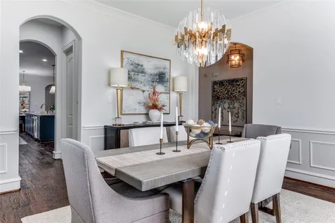a view of a dining room with furniture a chandelier and wooden floor