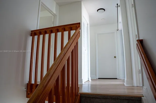 a view of a hallway with wooden floor and entryway