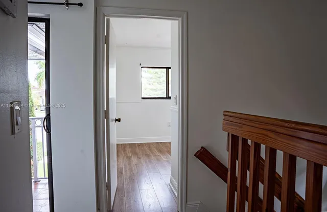 a view of a hallway with wooden floor