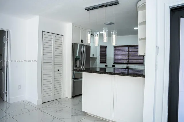 a kitchen with stainless steel appliances granite countertop a sink and a stove