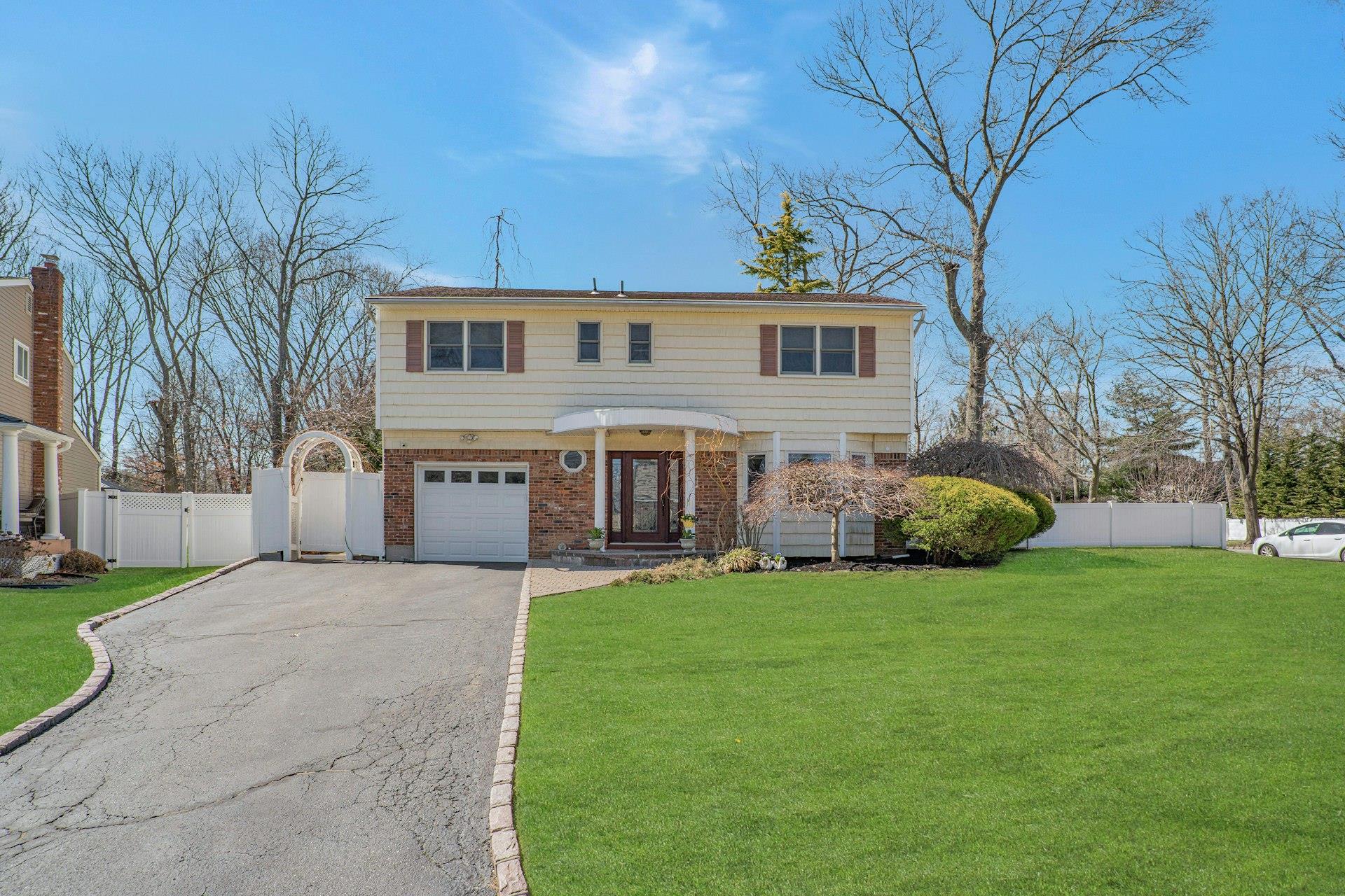 16 Glenmere Lane Commack, NY 11725 - Photo 1 of 1 View of front of property featuring driveway, a gate, fence, and a front lawn