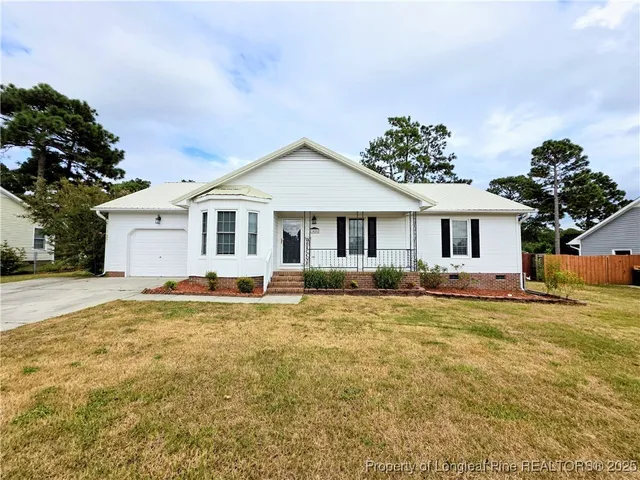 a front view of a house with a garden and yard