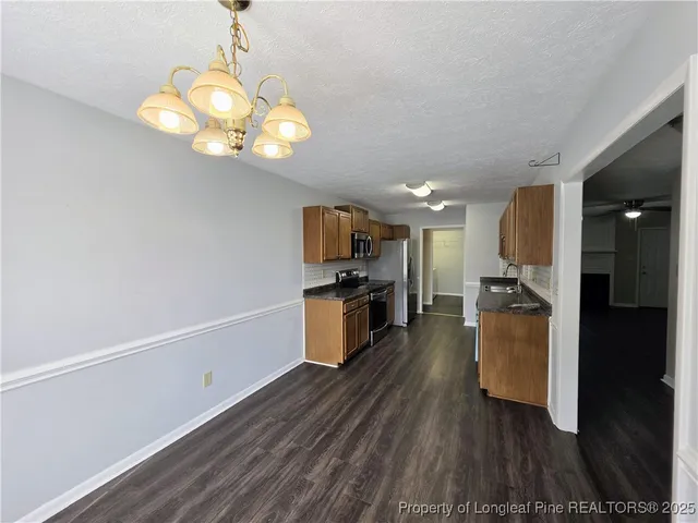 a kitchen with a refrigerator and a wooden floor