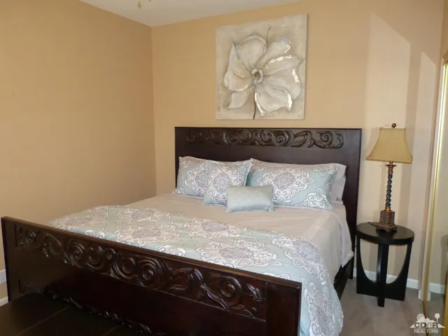 a bedroom with a bed and painting on the wall