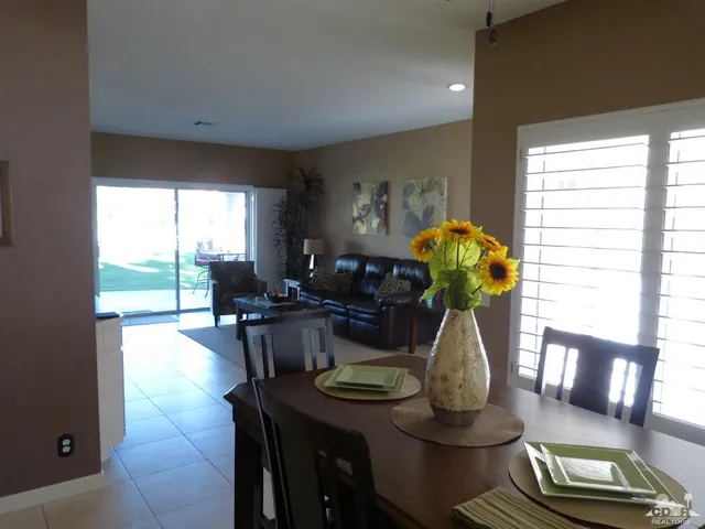 a dining room with furniture a chandelier and wooden floor