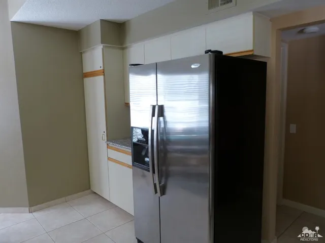 a metallic refrigerator freezer sitting in a kitchen