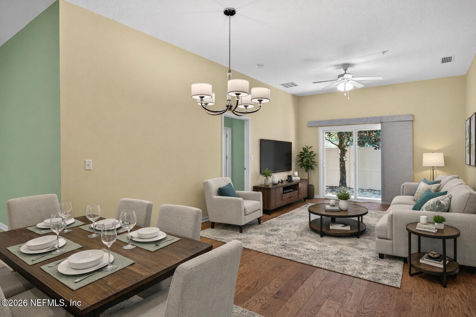 a living room with furniture a chandelier and a flat screen tv