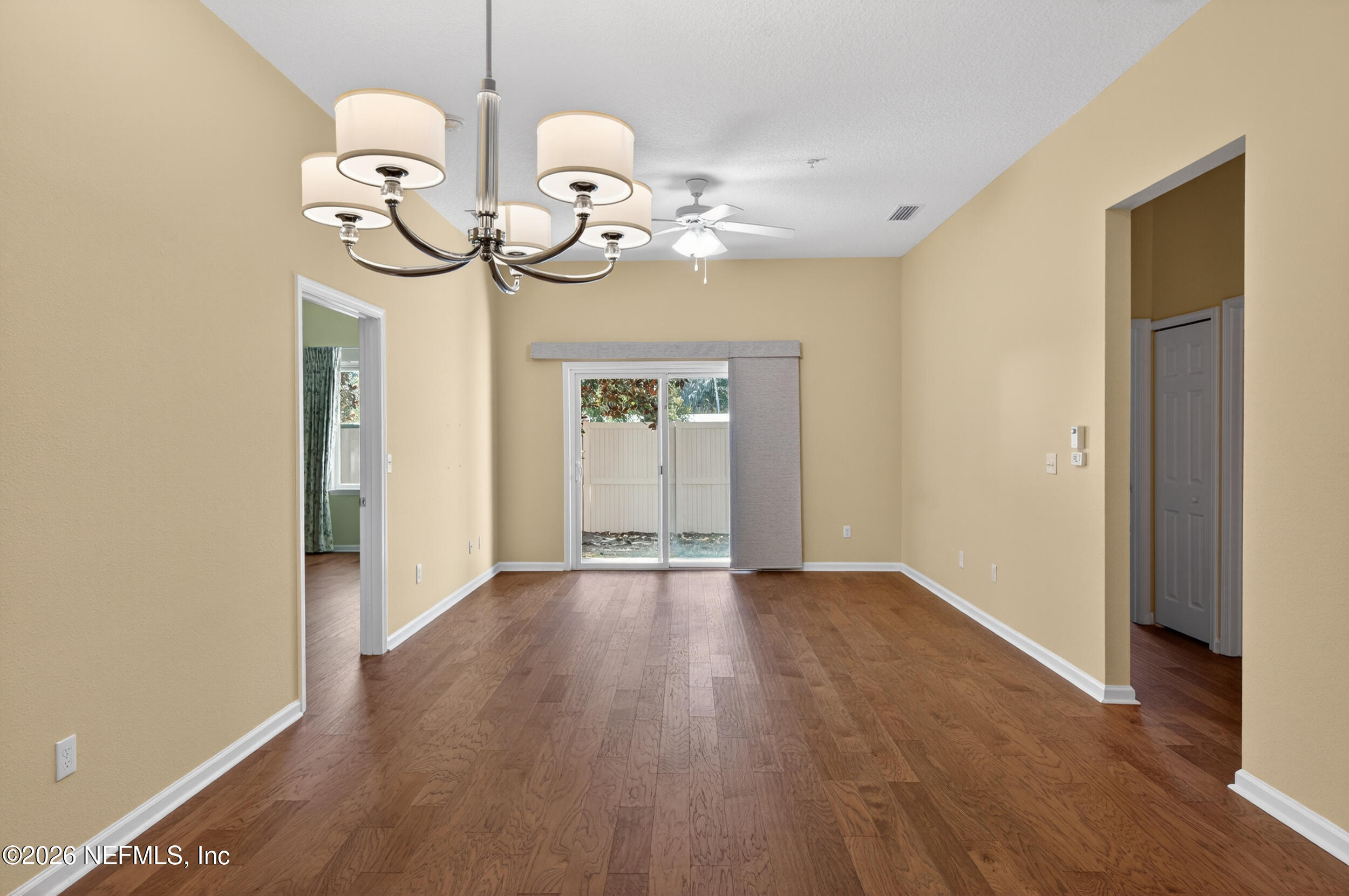 319 Golden Lake Loop St. Augustine, FL 32084 - Photo 2 of 15 an empty room with wooden floor fan and windows