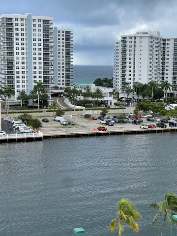 a view of ocean with boats and trees in the background