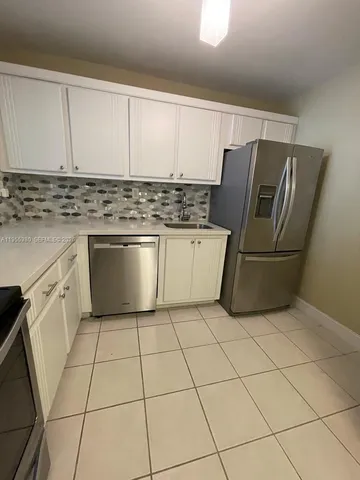 a kitchen with stainless steel appliances granite countertop a refrigerator sink and cabinets
