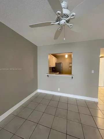 a view of an empty room with a chandelier fan