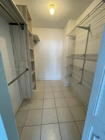 a view of a hallway with a chandelier and a dining table