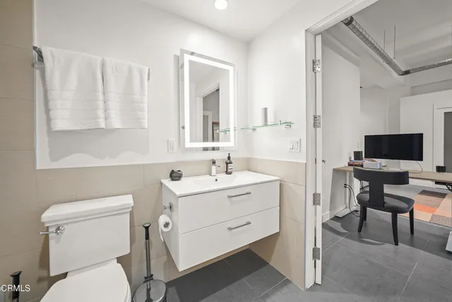 a view of a workspace with furniture and a window