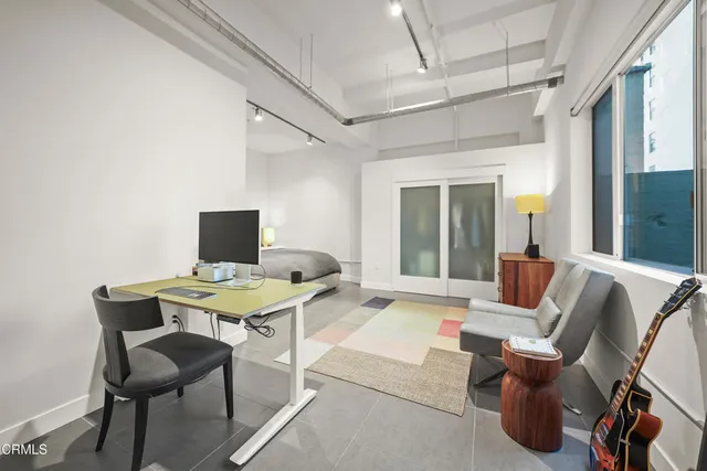 a bedroom with a bed a table and painting on the wall