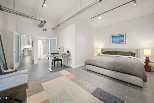 a bedroom with a bed and painting on the wall