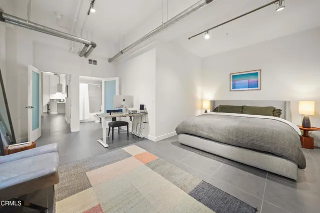 a bedroom with a bed and painting on the wall