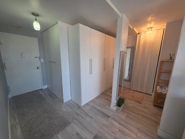 a view of a hallway with wooden floor and staircase