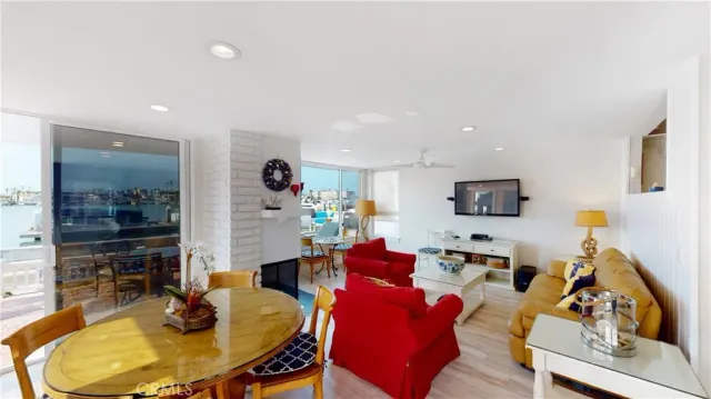 a living room with furniture kitchen view and a flat screen tv