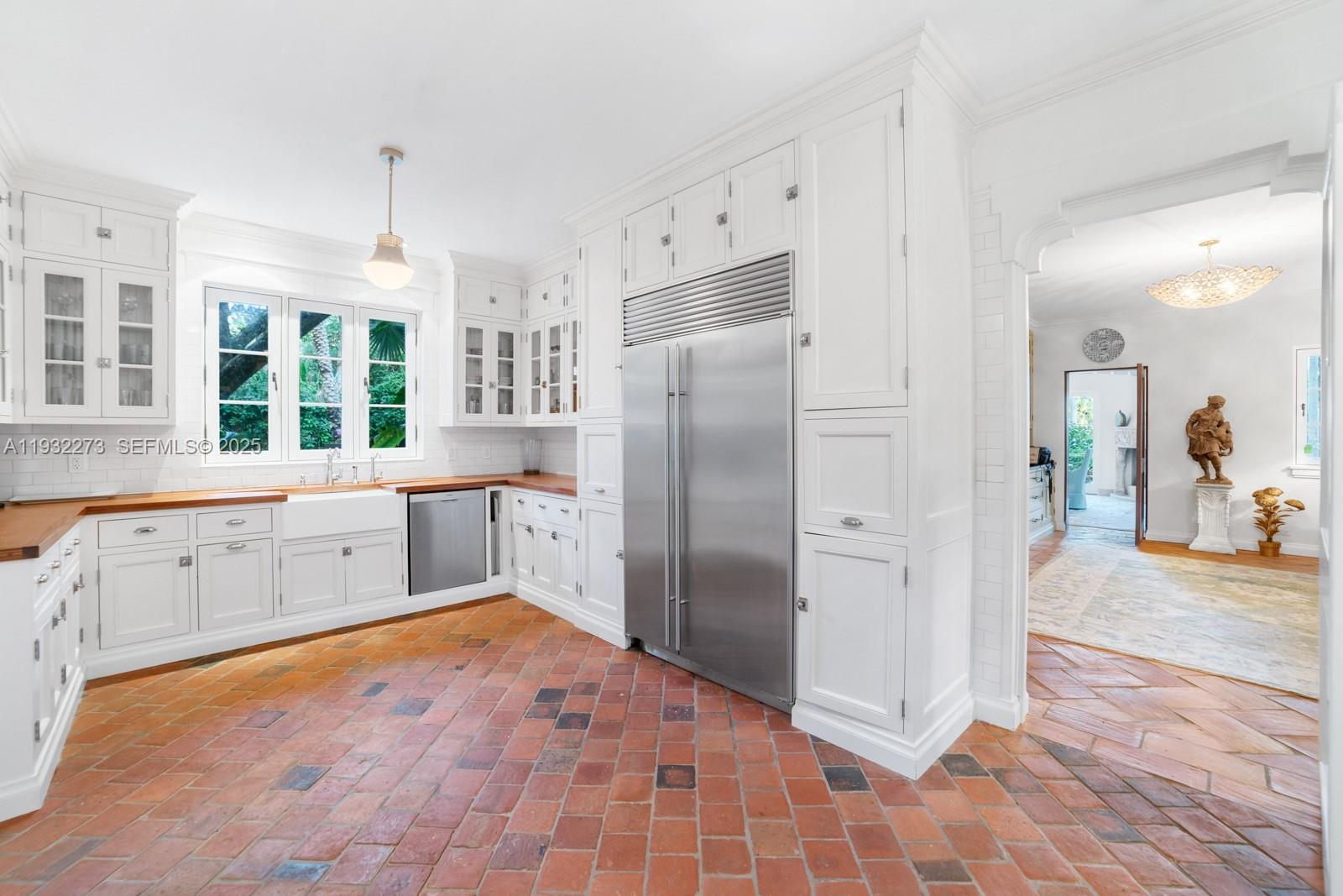 3467 North Moorings Way Miami, FL 33133 - Photo 18 of 25 a large white kitchen with granite countertop a refrigerator and a sink