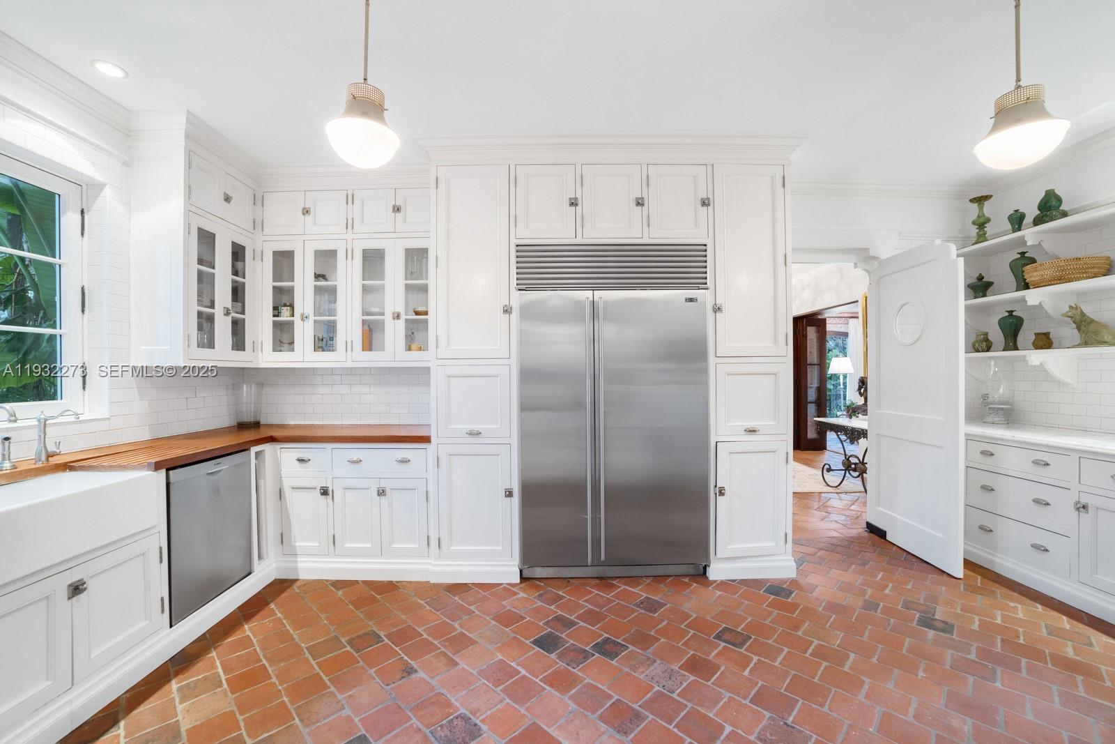 3467 North Moorings Way Miami, FL 33133 - Photo 19 of 25 a kitchen with granite countertop a refrigerator and a sink
