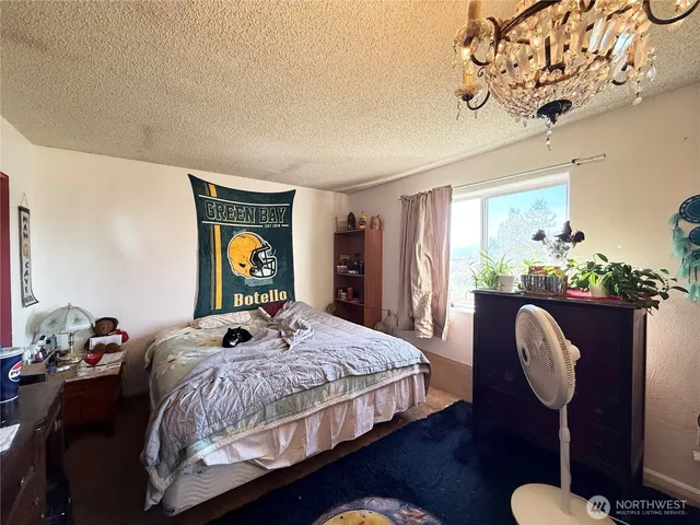 a bedroom with a bed mirror and window