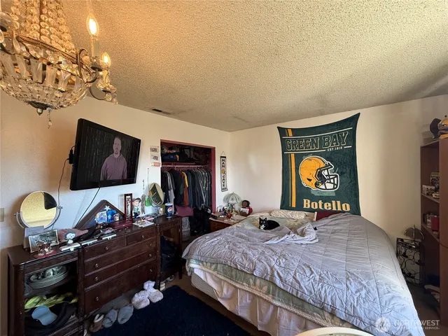 a bedroom with bed tv and a window