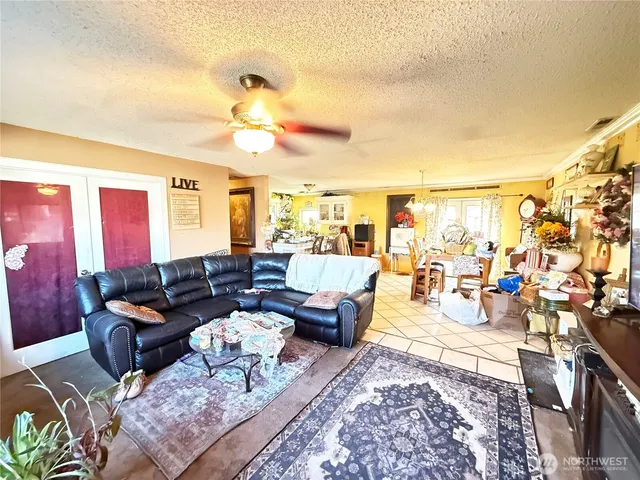 a living room with furniture a chandelier and a rug