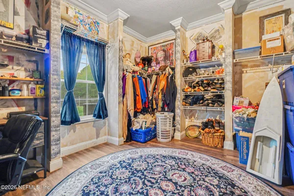 a view of walk in closet with clothes and shoes