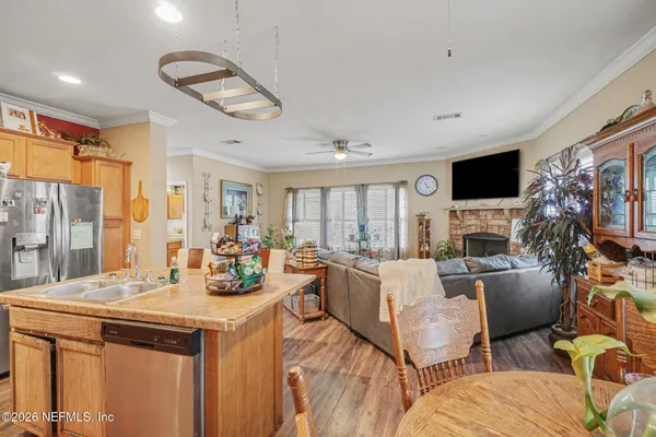a view of a dining room with furniture a fireplace and wooden floor