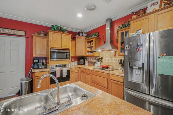 a kitchen with stainless steel appliances granite countertop a refrigerator a stove top oven a sink and dishwasher