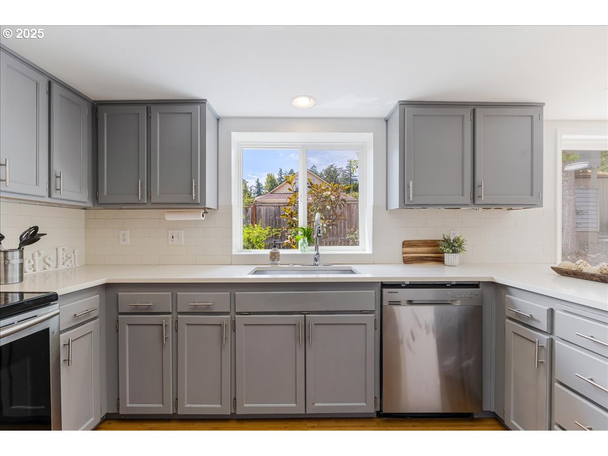 7505 Southwest Alpine Drive Beaverton, OR 97008 - Photo 11 of 48 a kitchen with kitchen island granite countertop a sink window and cabinets