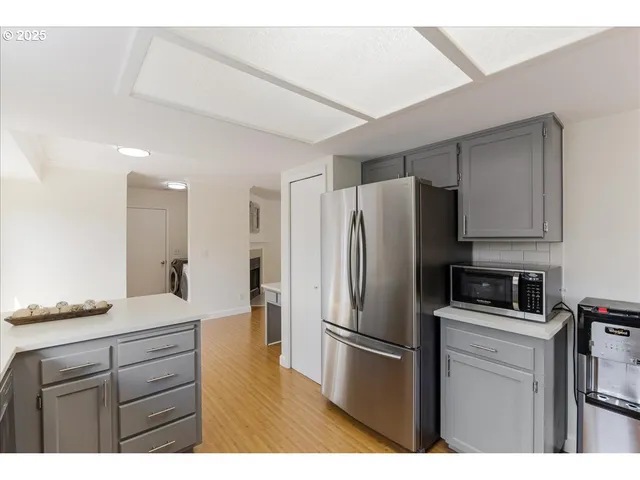 a view of empty room with wooden floor and a window