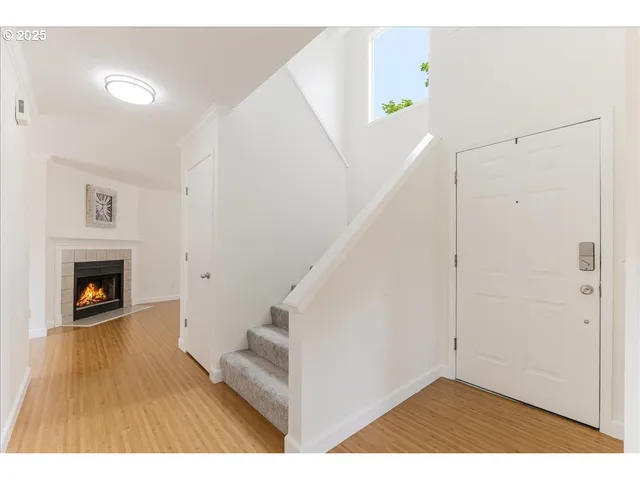 a view of an empty room with window and fire place