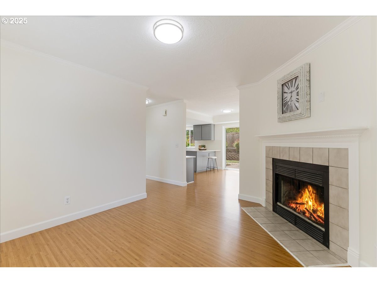 7505 Southwest Alpine Drive Beaverton, OR 97008 - Photo 7 of 48 a view of an empty room with wooden floor fireplace and a window