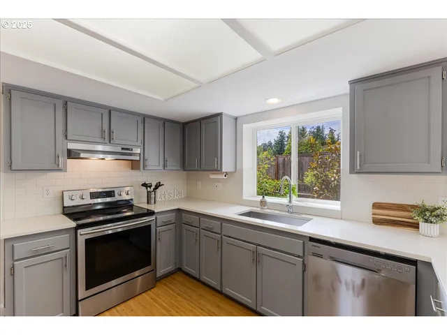 a kitchen with kitchen island granite countertop a sink window and cabinets
