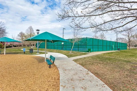 a view of pool with green space and trees in the background