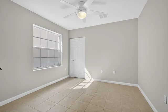 an empty room with an entryway and fan
