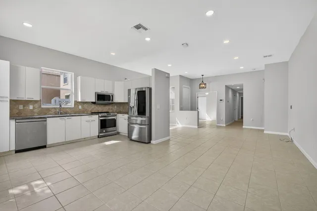 a kitchen with granite countertop stainless steel appliances and white cabinets