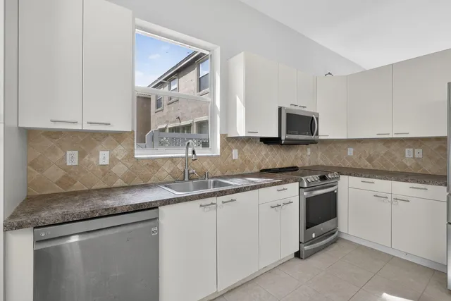 a kitchen with a sink and stainless steel appliances
