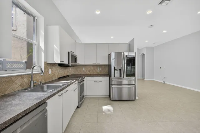 a kitchen with stainless steel appliances a refrigerator and a stove