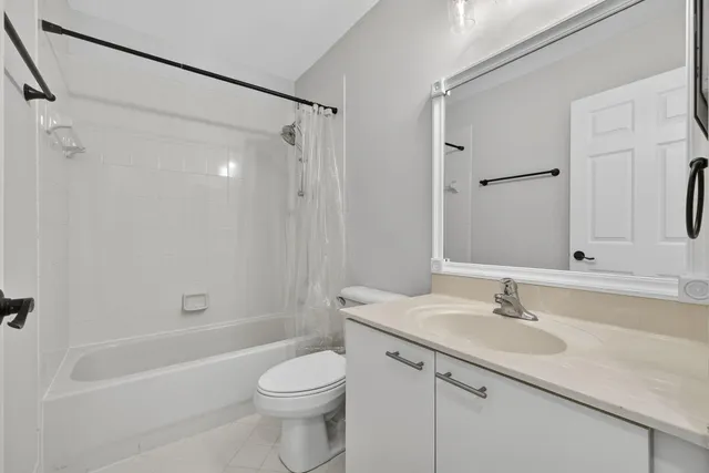 a bathroom with a granite countertop sink a toilet and shower