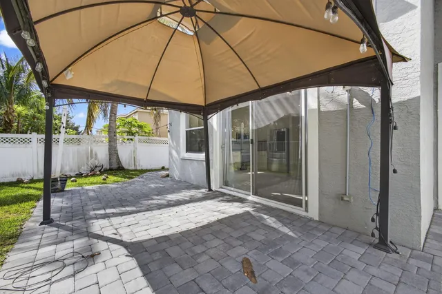a view of a house with a backyard and a tree