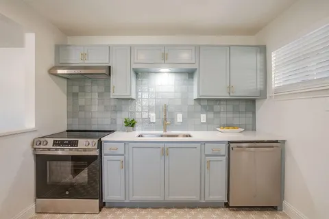a kitchen with a sink stove and cabinets