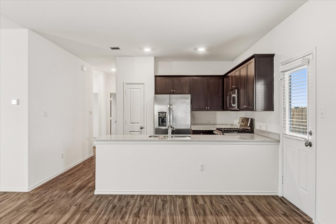 14105 Nightview Cove Pflugerville, TX 78660 - Photo 11 of 36 a kitchen with stainless steel appliances granite countertop a sink and cabinets