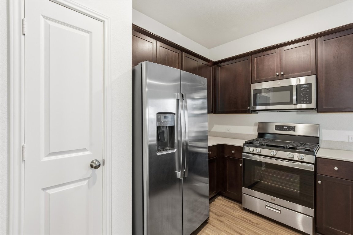 14105 Nightview Cove Pflugerville, TX 78660 - Photo 14 of 36 a kitchen with stainless steel appliances a refrigerator stove and microwave