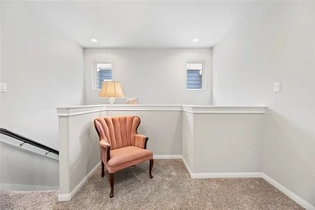 a hallway with a couch and a potted plant on a dresser