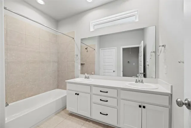 a bathroom with a double vanity sink mirror and bathtub