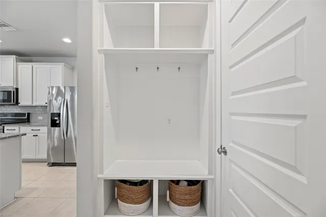 a kitchen with a refrigerator and white cabinets