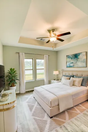 a bedroom with a large bed a chandelier and a potted plant